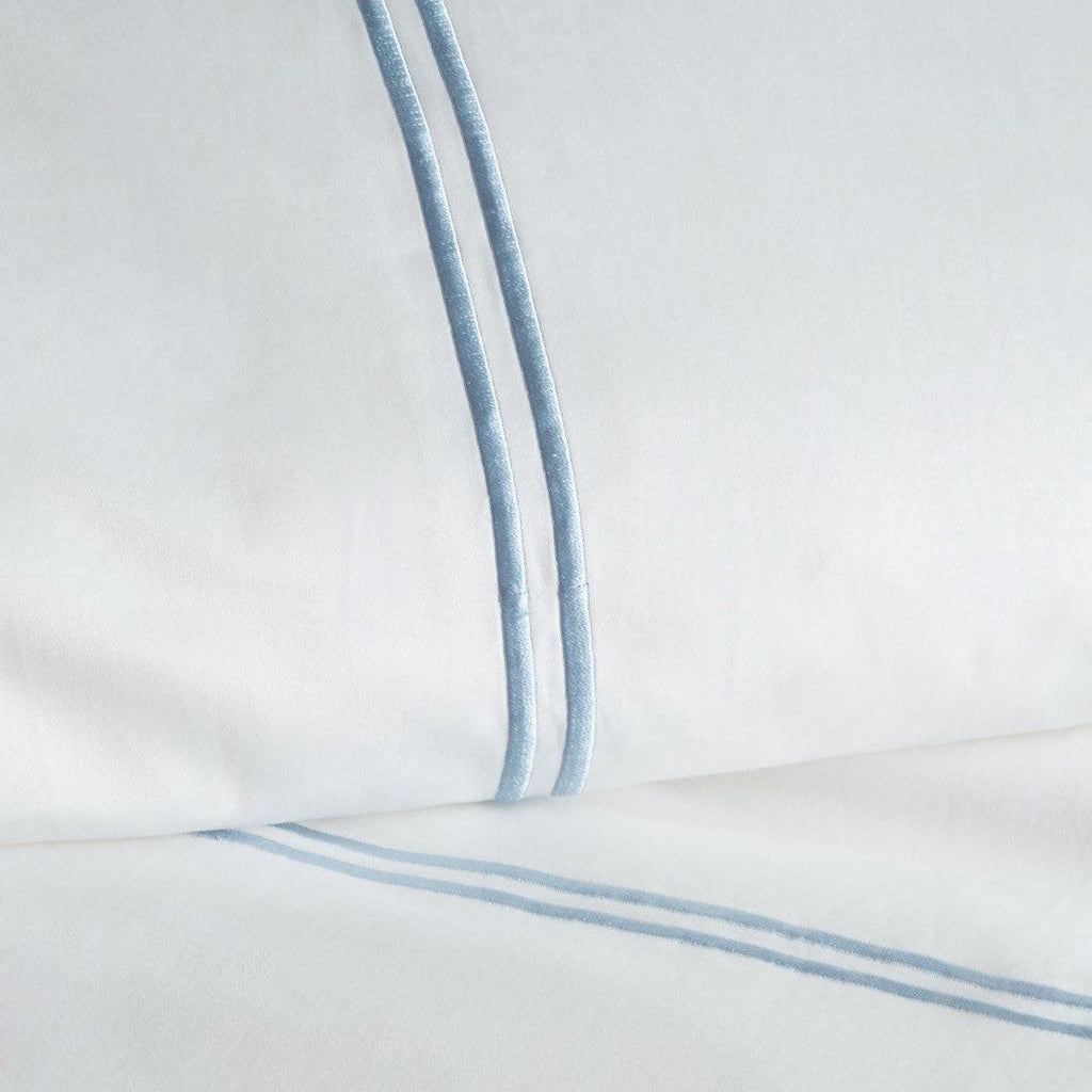 Close-up of a white pillow with blue stripes on a light gray background - The Well Appointed House