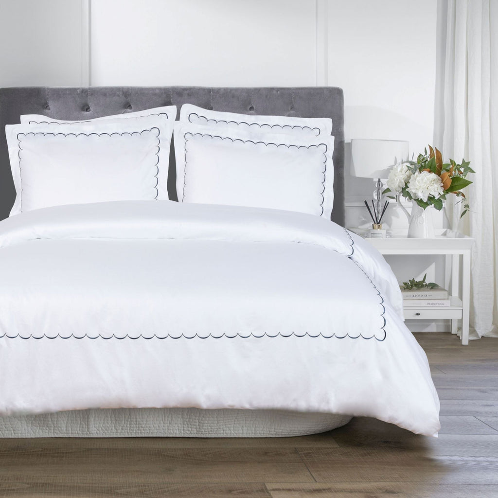White bedding set on a bed with a gray headboard in a bedroom setting- The Well Appointed House